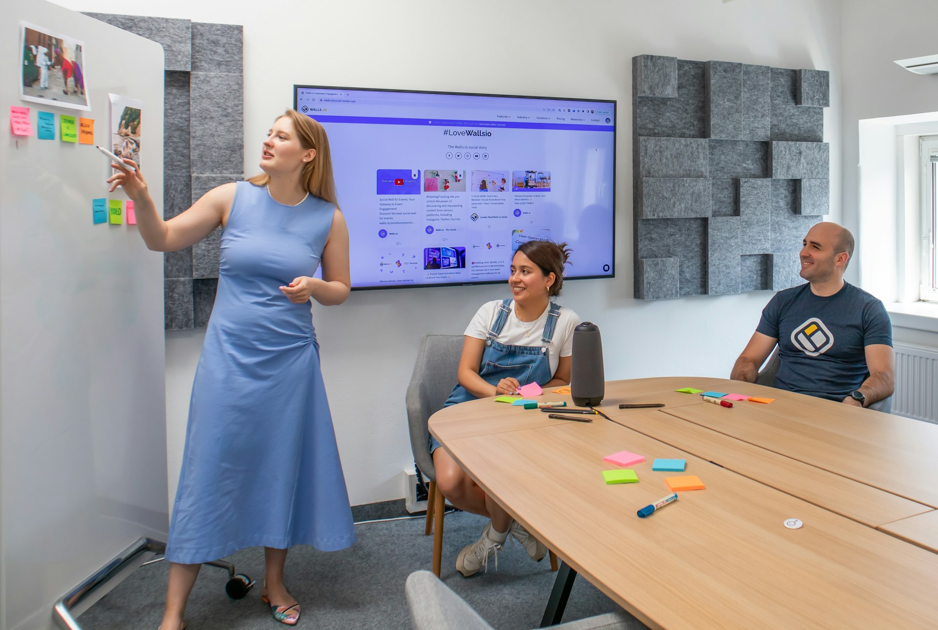 a woman standing in front of a whiteboard with sticky notes on it